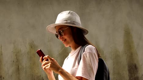 Smiling-female-traveler-using-smartphone