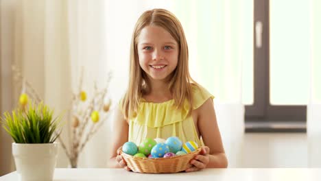 happy-girl-showing-colored-easter-egg-at-home