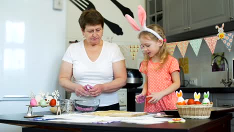 Chica-con-su-abuela-hornear-galletas-en-Pascua