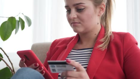 Woman-shopping-online-with-cellphone-and-credit-card