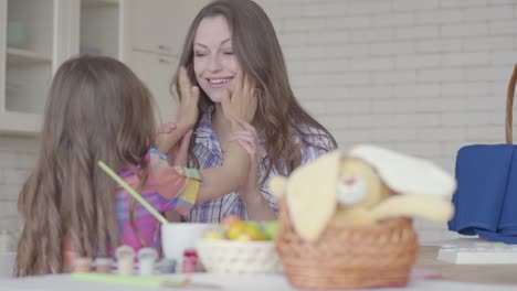 Young-mother-and-cute-girl-chatting-on-the-kitchen.