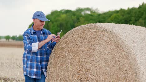 Moderne-Landwirtschaft.-Die-Liebe-zur-Landwirtschaft.-Landwirt-mit-digitalem-Tablet-bei-der-Prüfung-von-Bauernhof