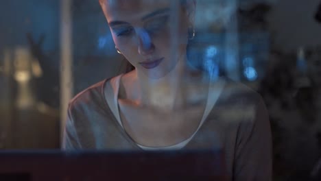 Junge-Frau-verbindet-sich-mit-ihrem-Laptop-neben-einem-Fenster