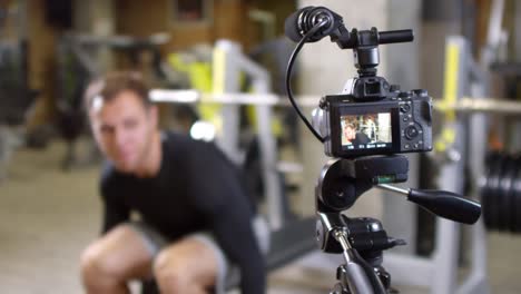 Fitness-Coach-Explaining-and-Showing-Side-Dumbbell-Raise-on-Camera