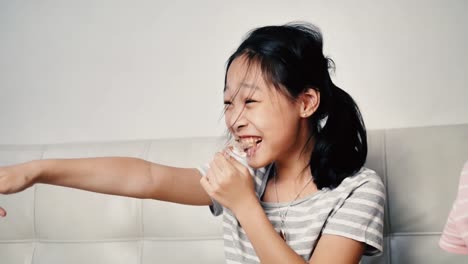 Lachende-asiatische-Mädchen-essen-Chips-mit-Familie-zu-Hause-in-der-Nacht.