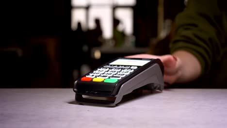 Close-up-shot-of-person-swipes-credit-card-through-terminal-machine-performing-payment.