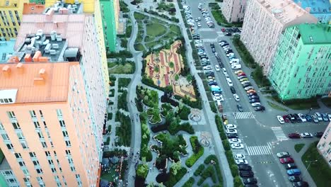 drone-se-eleva-por-encima-de-un-hermoso-parque-en-una-zona-residencial-con-casas-de-colores