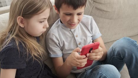 Children-using-mobile-phone-on-sofa