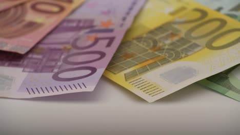 4K-Primer-plano-de-una-moneda-de-un-euro-con-billetes-de-diferentes-valores.-Dinero-en-efectivo