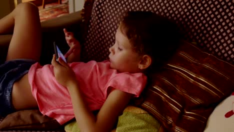 Little-girl-playing-in-game-on-smartphone