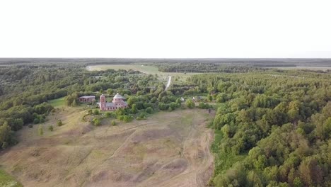 Aerial-view-of-the-Russian-forest,-river-and-steppe-overlooking-an-abandoned-Church-and-architectural-objects