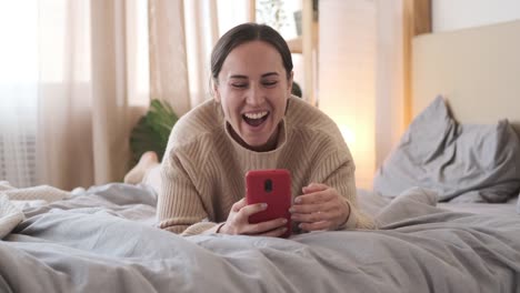 Mujer-feliz-enviando-mensajes-de-texto-en-el-teléfono-móvil