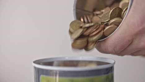 Pouring-euro-coins-into-a-jar-close-up