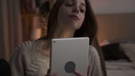 Nachdenkliche-teen-Mädchen-mit-digitalen-Tablet-zu-Hause