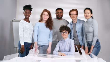 Cheerful-Teacher-Posing-with-Multiethnic-Students-in-Futuristic-Classroom