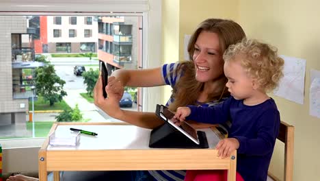 Mother-with-child-shoot-selfie-photographs-with-smartphone.