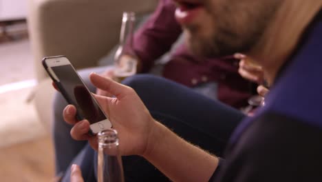 Man-Checking-Mobile-Phone-At-Party-With-Friends