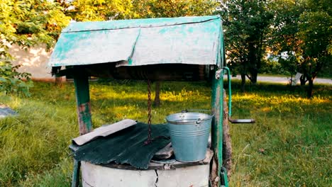 Con-agua,-es-cubo-del-hierro-a-su-lado.-Extracción-de-agua-en-las-zonas-rurales.-Vida-sin-agua-corriente