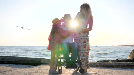 inválido-en-silla-de-ruedas-con-hijita,-frotando-a-la-mujer-embarazada-del-vientre-de-las-madres-y-discapacitado-familia-feliz-hombre