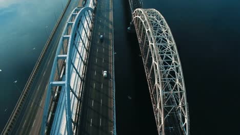 Cars-and-train-moves-on-a-bridge-over-a-frozen-river-aerial-drone-footage