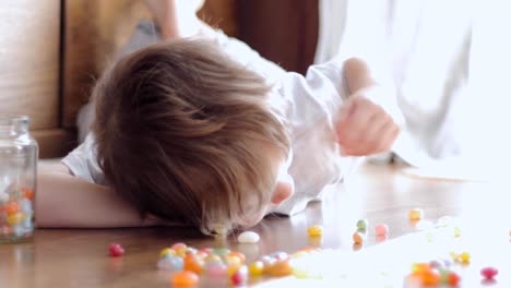 süsser-Boy-spielen-mit-bunten-Bonbons