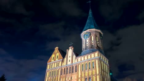 Illumination-on-a-historic-building.-Historic-Landmark.-Time-lapse.-Cathedral-of-Kant-in-Kaliningrad.-Old-medieval-castle-at-night-against-the-sky.-An-ancient-tower-with-a-clock.-Timelapse.