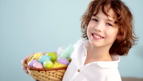 Lindo-niño-con-una-cesta-de-Pascua-sonriendo-mirando-a-la-cámara