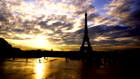 Grupo-de-turistas-mirando-la-Torre-Eiffel-con-fondo-puesta-de-sol