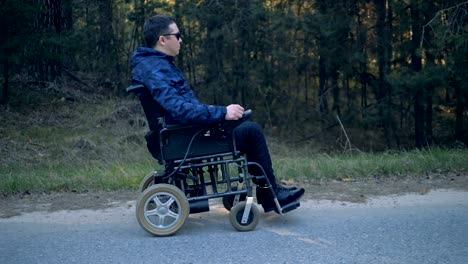 Man-in-a-wheelchair-enjoys-nature,-side-view.