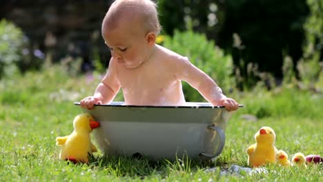 Cute-child,-playing-with-little-bunny-and-easter-eggs-in-a-blooming-garden,-springtime.-Boy-play-with-rabbit,-egg-hunting-for-holiday