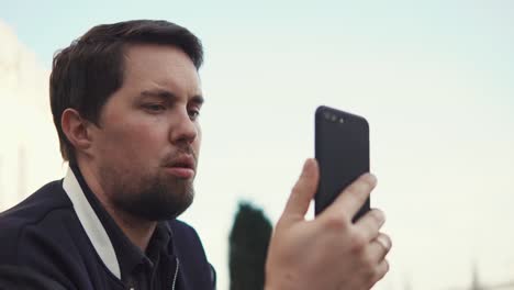 young-businessman-talking-to-business-partner-on-phone-outdoors-in-the-daytime