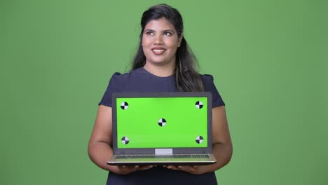 Young-overweight-beautiful-Indian-businesswoman-against-green-background