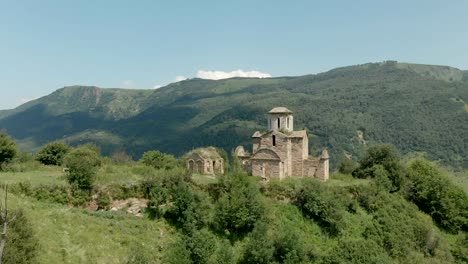 Abfahrt-auf-einer-Drohne-aus-der-alten-baufälligen-christlichen-Kirche-steht-hoch-auf-dem-Berg.-Luftaufnahme.-Nord-Kaukasus.-Russland