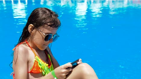 A-child-is-playing-with-a-phone-in-the-pool.