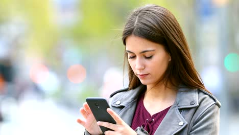 Adolescente-seria-viendo-el-contenido-del-teléfono-inteligente-al-aire-libre