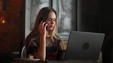 Lächelnde-Hipster-Mädchen-im-Gespräch-mit-Freund-per-Videoanruf-über-Laptop-Computer-sitzend-in-Coffee-Shop.-Fröhliche-Managerin-mit-Webinar-über-portable-Notebook-während-der-Ruhezeit-im-café