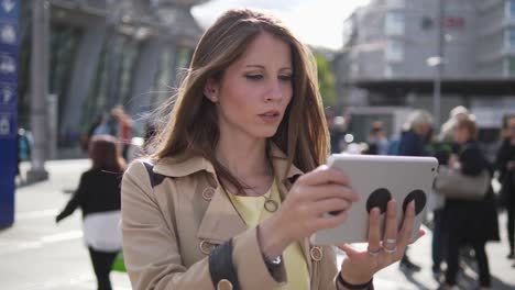 Pretty-Caucasian-woman-communicating-by-sending-text-messages-on-digital-tablet