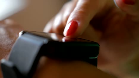 Woman-using-his-smartwatch-app.-Closeup.-Businesswoman-using-trendy-smart-watches-mobile-application-on-touch-screen.-Girl-using-her-smartwatch-touch-screen-wearable-technology-device.-Close-Up.