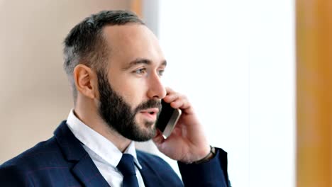 Close-up-Portrait-von-attraktiven-lächelnd-männlichen-Geschäftsmann-im-Gespräch-mit-smartphone