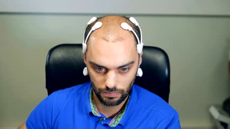 Man-wearing-robotic-Brainwave-Scanning-sensors-on-his-head,-close-up.