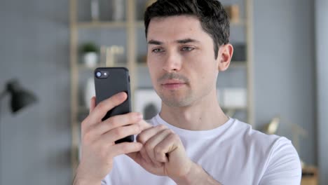 Portrait-of-Young-Man-Busy-Using-Smartphone