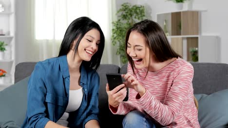 Frauen-lachen-beim-Lesen-von-Smartphone-Inhalten