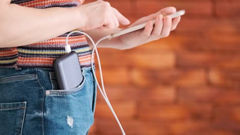 Frau-mit-Smartphone-beim-Laden-auf-der-Powerbank.