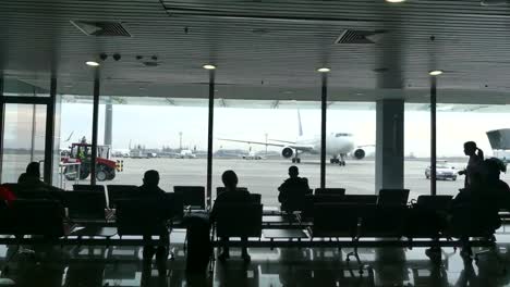 Passengers-at-the-airport-waiting-for-boarding.-Passengers-awaiting-landing-at-the-airport.-In-the-background-is-a-plane.