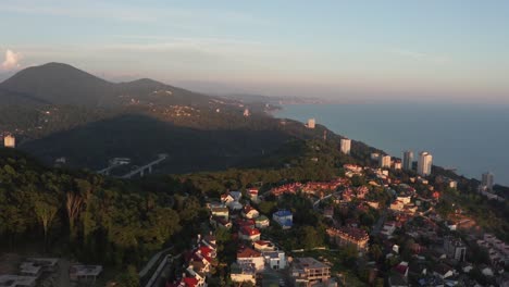 Aerial-video-shooting.-Sunset-over-the-city-of-Sochi.-Evening-light.-Haze-over-the-city.-Residential-area.-Black-sea-coast.-Panorama-shooting.-The-view-from-the-top.-Yellow-light