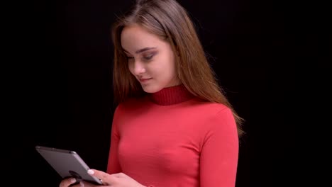 Closeup-portrait-of-young-beautiful-caucasian-female-watching-a-video-on-the-phone-then-looking-at-camera-and-smiling