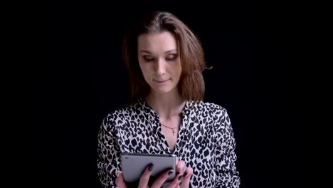 Closeup-portrait-of-young-stunning-caucasian-brunette-female-using-the-tablet-and-reacting-to-social-media-posts-in-front-of-the-camera