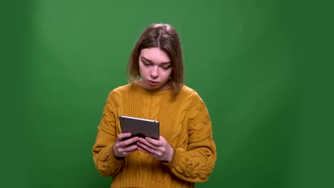 Sesión-de-primer-plano-de-joven-atractiva-mujer-de-pelo-corto-usando-la-tableta-con-fondo-aislado-en-verde