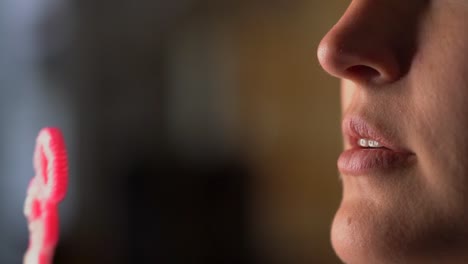 closeup-macro-lips-blowing-bubbles-from-pink-bubble-wand