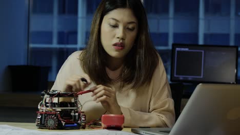 Female-electronics-engineer-working-with-robot-project-at-lab.-Technology-and-innovation-concept.